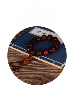 Macro detail of sandalwood beads with carved Buddha pendant on vintage book background