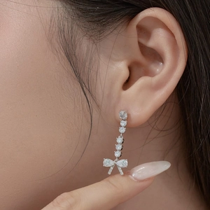 Close-up of S925 sterling silver drop earrings with bow pendant and sparkling crystals
