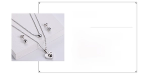 Vue détaillée du set pendentif cœur et patte en acier plaqué or 18K avec boucles d'oreilles