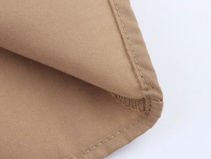 Detail of khaki fabric showing professional double-stitch sewing and cotton texture