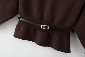 Close-up of ribbed knit fabric in dark brown with a slim black leather belt and gold buckle