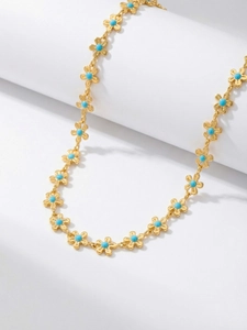 Détail du collier en acier inoxydable plaqué or 18 carats avec fleurs en émail bleu