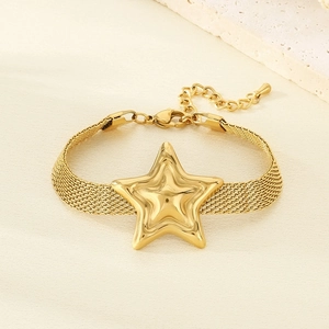 Detail of gold star charm on woven mesh watchband style bracelet with lobster clasp