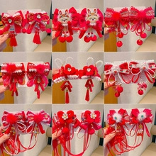 Close-up of 9 pairs of red Chinese New Year hair clips with tassels and bows