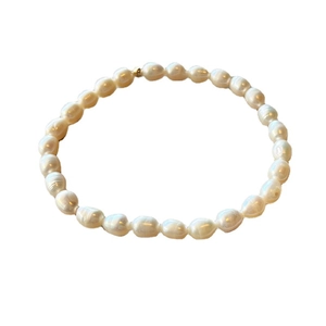 Minimalist freshwater baroque pearl bracelet with 14K gold bead on white background