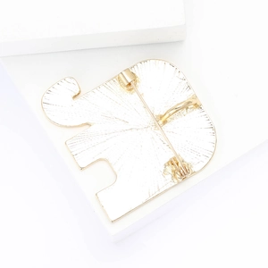 Detail of the golden elephant brooch back showing pin clasp and metallic texture