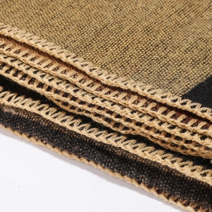 Detail of khaki reversible plaid shawl with black whipstitch edges and woven texture