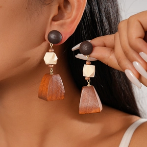 Détail de boucles d'oreilles géométriques en bois avec éléments circulaires et cubiques