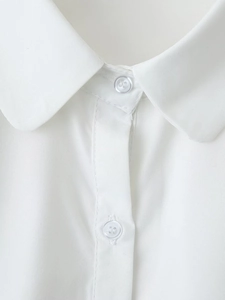 Close-up of a white cotton shirt collar with standard lapel and two white buttons
