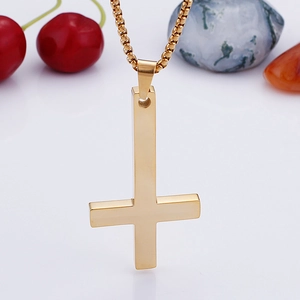 Close-up of a polished gold inverted cross pendant with a classic box chain necklace