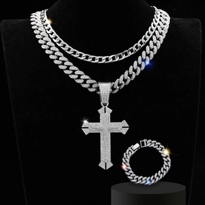 Detailed view of silver iced-out cuban link necklaces and bracelet with cross pendant