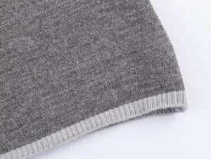 Detailed macro view of the premium grey knit fabric and ribbed cuff craftsmanship
