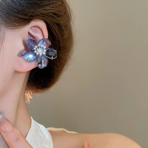 Macro detail of blue crystal flower ear cuff with zircon center on model ear