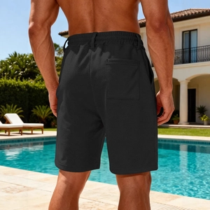 Men's black quick-dry casual beach shorts with back pocket shown in a poolside setting