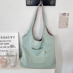 Detail of mint green suede tote bag with leopard print lining and front pocket label