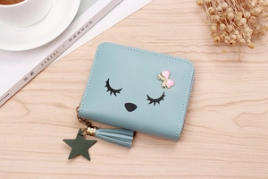 Detail of light blue cartoon coin purse with pink bow, tassel and star pendant
