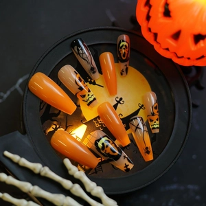 Macro view of Halloween long coffin press-on nails with pumpkin and ghost motifs