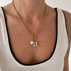Detail of 18k gold plated chain featuring baroque pearl and blue floral ceramic charms