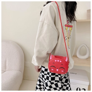 Girl wearing a cute red cat-shaped PU crossbody bag with soft woven strap in home setting