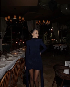 Close-up of side ruching and shoulder pads on a navy blue bodycon dress with long sleeves