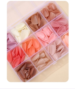 Detailed view of 12-color almond nail tips set in a transparent 10-grid storage box
