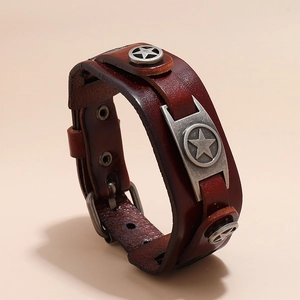 Dettaglio del bracciale in pelle marrone scuro con placca in metallo vintage e borchie a stella