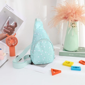 Detail of light blue nylon kids chest bag featuring white star prints and a zipper closure