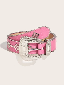 Detail of pink faux crocodile leather belt with silver studs and western floral buckle