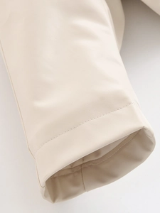 Detail shot of cream leather jacket cuff featuring fine stitching and smooth texture