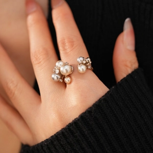 Close-up of elegant open ring with white and grey pearls and cubic zirconia on a model