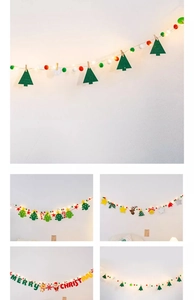 Detail of Christmas felt hanging ornaments with LED lights and wooden clips on white wall