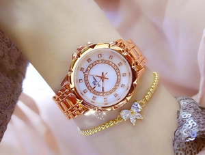 Close-up of rose gold women's watch with crystal-encrusted bezel and bow bracelet