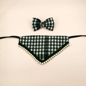 Detail view of houndstooth plaid pet bandana and bow tie with pearl trim on pink backdrop