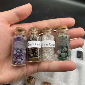 Close-up of four mini corked glass bottles filled with Amethyst, Tiger Eye and quartz stones