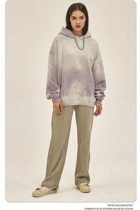 Detail van een paarse gradiënt vervaagde hoodie en een kaki broek met brede pijpen