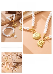 Detail of gold-plated OT clasp pearl jewelry with starfish and scallop charms