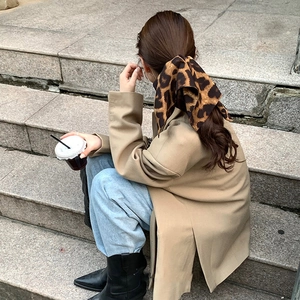 Detail of leopard print satin scrunchie tied on a high ponytail for a retro look