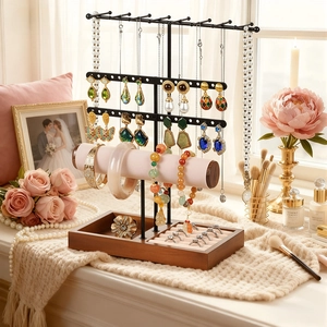 Multi-tier jewelry display stand with wooden base and pink velvet bracelet bar in a room