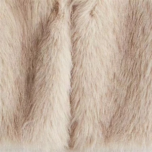 Macro detail of soft beige faux fur texture showing high density and fluffy long hair fibers