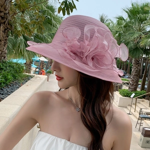 Elegant pink wide-brim sun hat with large organza floral detail for summer beach vacation