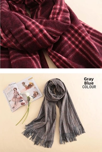 Detailed view of thick cashmere-feel plaid scarves with elegant tassels in grey blue and red