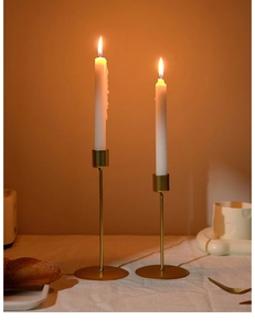 Detail of two gold metal candle holders in different heights on a romantic dining table