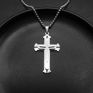 Macro shot of silver triple-layered cross pendant in stainless steel on black display