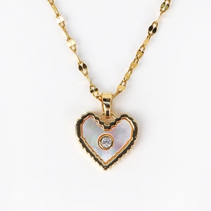Detail of gold heart necklace with white mother of pearl inlay and center crystal