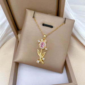 Detail of gold tulip pendant with pink pear-shaped gem and crystals in a gift box