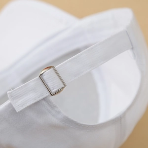 White cotton baseball cap featuring an adjustable rear strap with a silver metal buckle
