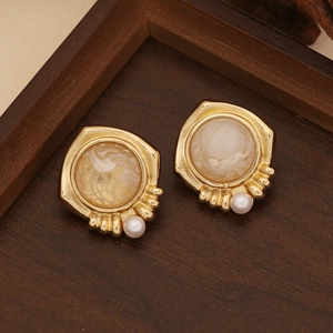 Vintage gold flower earrings with marble texture resin and white pearls on wood