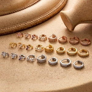 Assortiment de créoles en or et argent avec zircons et breloques papillon dorées