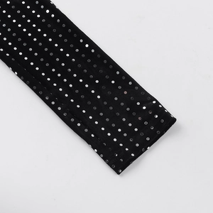 Detailed macro view of sparkling silver sequins on black velvet evening dress fabric