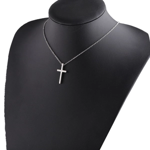 Polished stainless steel cross pendant necklace displayed on a black leather neck bust